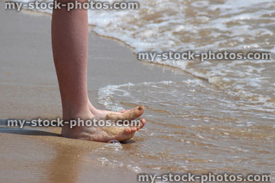 Stock image of girl paddling in sea waves, legs, beach, barefoot, curling toes
