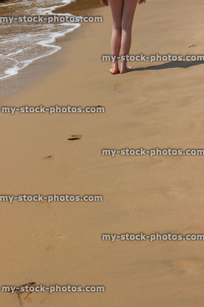 Stock image of footprints in sand by sea, beach footprints, barefoot girl / legs
