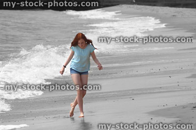 Stock image of girl walking barefoot on beach, black and white / colour spolight