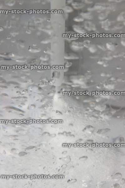 Stock image of fizzy water, soda water being carbonated with carbon dioxide bubbles