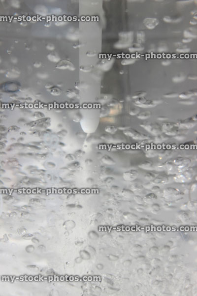 Stock image of fizzy water, soda water being carbonated with carbon dioxide bubbles