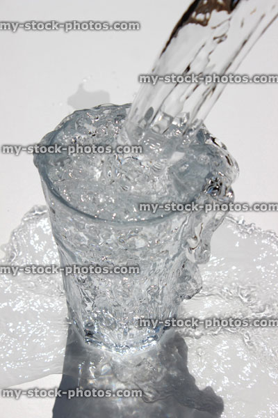 Stock image of water being poured into diner glass, splashing, sparkling