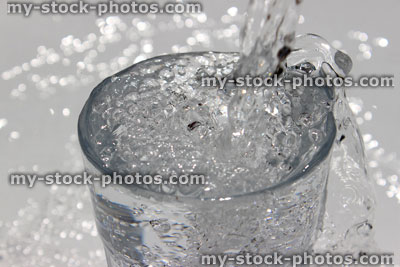 Stock image of water being poured into diner glass, splashing, sparkling