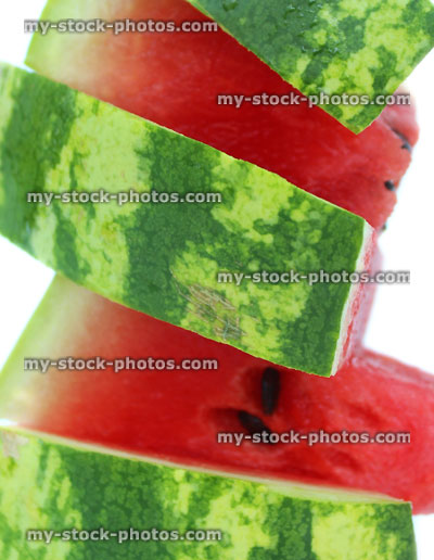 Stock image of watermelon slices showing red flesh and green skin