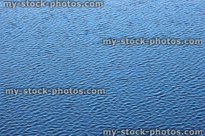 Stock image of small blue ripples on water's surface, reflecting sky