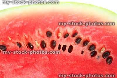 Stock image of red watermelon flesh with black seeds / melon pips