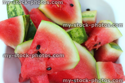 Stock image of watermelon triangle slices / wedges on plate, showing red flesh