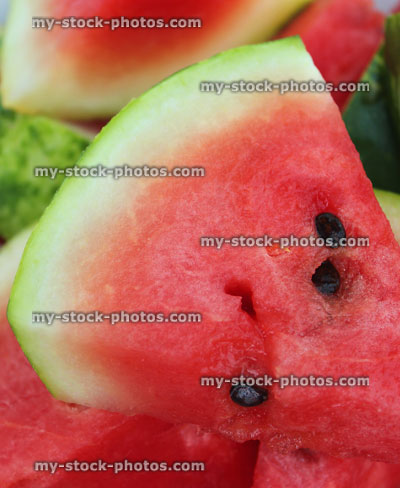 Stock image of watermelon pie shaped slices / segments showing red flesh / seeds