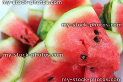 Stock image of watermelon slices / chunks on white plate, cut into triangles