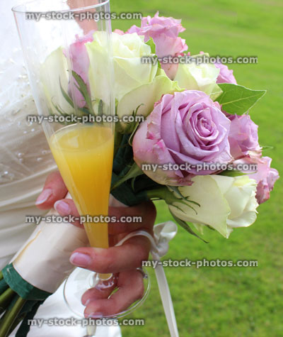 Stock image of bride wearing white wedding dress, bridal bouquet, flowers, champagne glass, bucks fizz