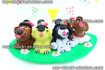 Stock image of homemade cake topper (polymer clay), cartoon dogs in row wearing top hats