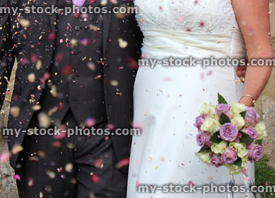 Stock image of newly married couple, bride and groom with confetti