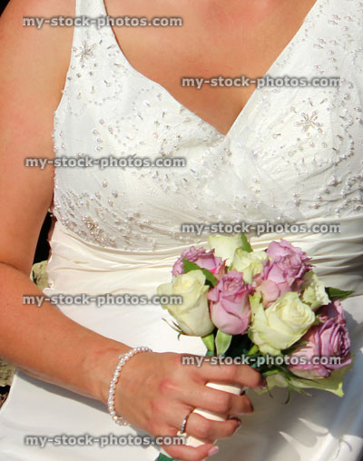 Stock image of newly married bride wearing white wedding dress, bridal bouquet, flowers