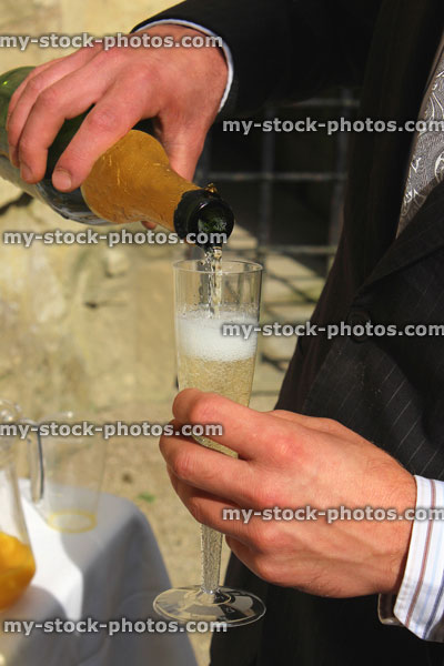 Stock image of bridegroom pouring champagne at wedding, champagne glass / flute, sparkling wine