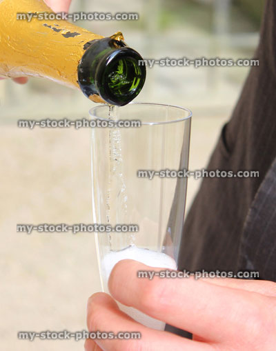 Stock image of bridegroom pouring champagne at wedding, champagne glass / flute, sparkling wine