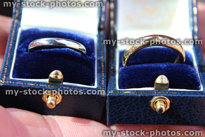 Stock image of wedding rings in boxes, platinum and gold, bride and groom
