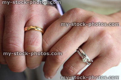 Stock image of bridge and groom holding hands, wedding rings, married