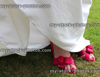 Stock image of bride wearing white wedding dress and pink shoes