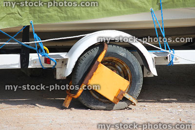 Stock image of trailer tyre with metal yellow wheel clamp