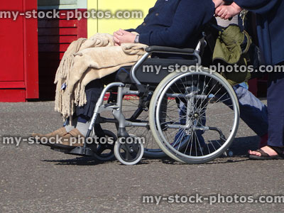 Stock image of disabled man being pushed in wheelchair / pathway