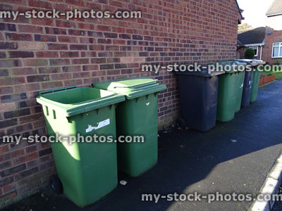Stock image of wheelie bins lined up for refuse collection / bin men