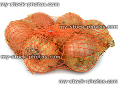 Stock image of dried white onions, white background, orange net bag