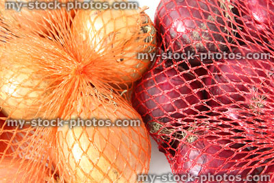 Stock image of red and white onions, sold in string net bags