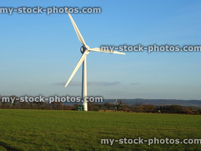 Stock image of wind turbine windmill in farm field, generating power