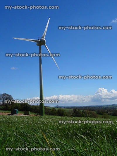 Stock image of farm field in countryside, modern wind turbine windmill