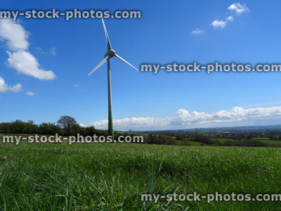 Stock image of countryside landscape with green field, wind turbine windmill