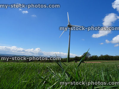 Stock image of grass farm field with low wind turbine windmill