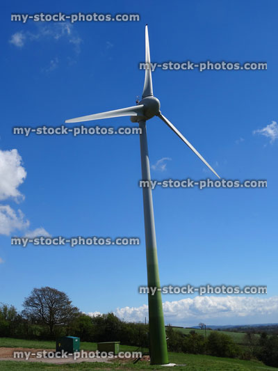 Stock image of countryside with wind turbine windmill turning, generating power