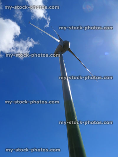 Stock image of green pillar base of wind turbine windmill against blue sky