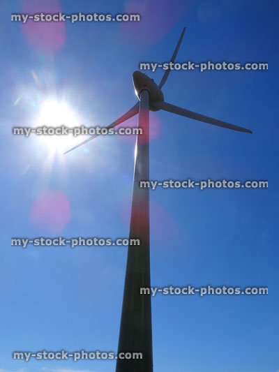 Stock image of wind turbine with windmill sails against sunny sky