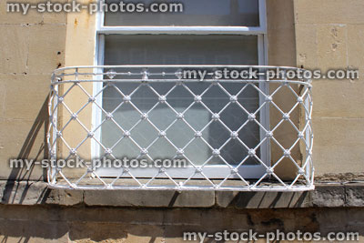 Stock image of ornate iron safety guard in front of window