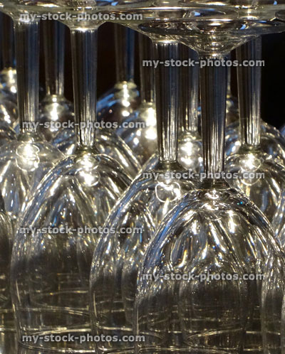 Stock image of upturned clear wine glasses sparkling in light, bar