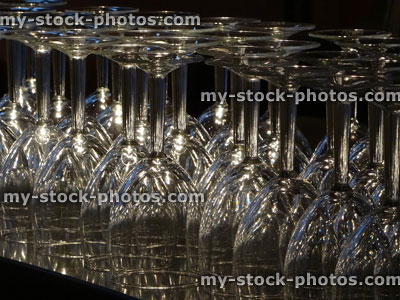 Stock image of upturned clear wine glasses sparkling in light, bar