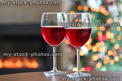 Stock image of Christmas tree fairylight decorations, red wine glasses, gas fire
