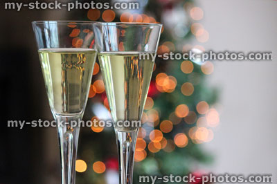 Stock image of glass champagne flutes of wine with Christmas fairylights