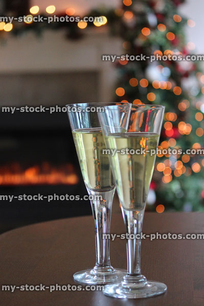 Stock image of wine glasses on table, Christmas tree, fairylights, fireplace