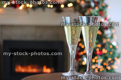 Stock image of sparkling white wine / glasses on Christmas table, fireplace, fairylights