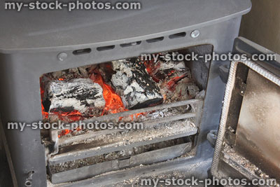 Stock image of wood burning stove with door open, showing fire
