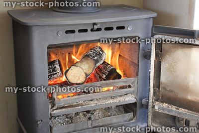 Stock image of roaring fire / flames, wood burning multi fuel stove / fireplace, door open