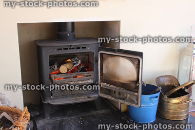 Stock image of modern fireplace, woodburning stove, coal buckets, log basket