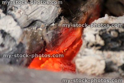 Stock image of burning fire with flames, hot embers, ash, logs