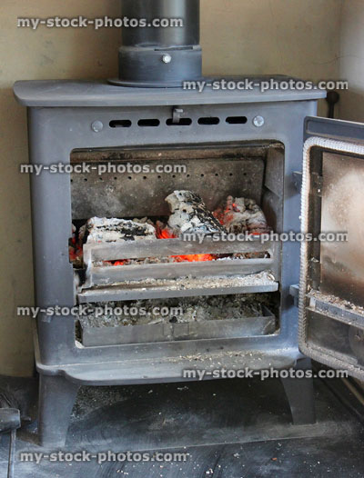 Stock image of cast iron multi fuel stove burning wood, fire / flames, open door