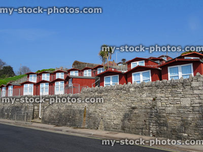 Stock image of some wooden beach huts with double doors, above promenade