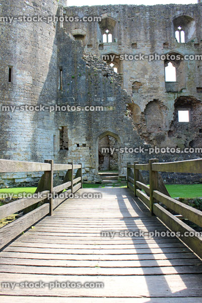 Stock image of wooden bridge leading to ancient castle ruins, over surrounding moat