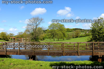 Stock image of simple wooden bridge in rural countryside, crossing stream