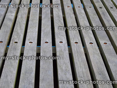 Stock image of weathered decking timber planks with wide spaced gaps